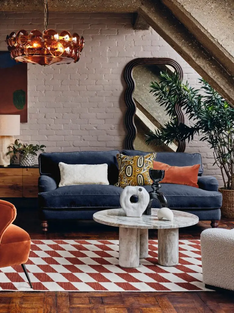 sala com sofá azul e tampete com estampa geométrica terracota