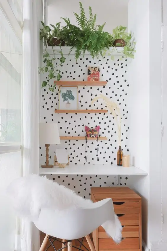 home office com parede de bolinhas polka dot pretas, no peqeno espaço.